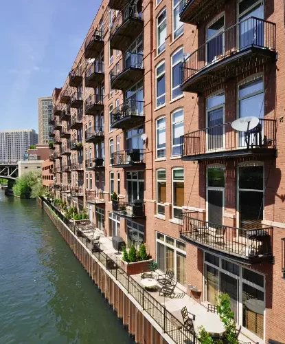 An image of a multi-family building with balconies along Chicago river