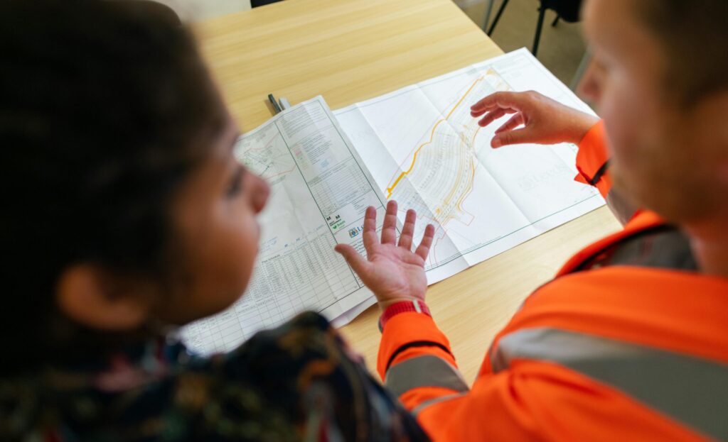 A construction worker discussing a preconstruction project plan with a property manager