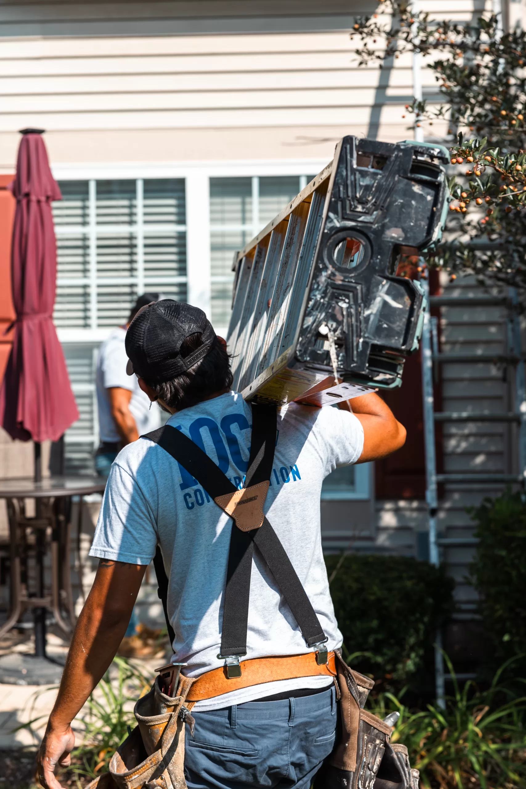 Construction wokrer carrying a ladder