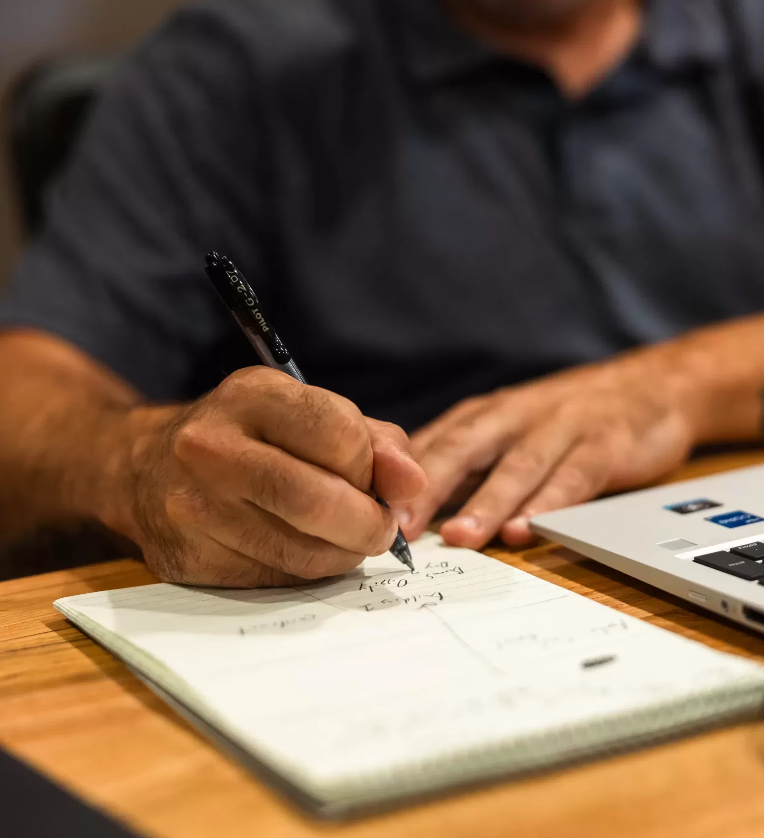 A close up of a man writing down project notes for a construction project