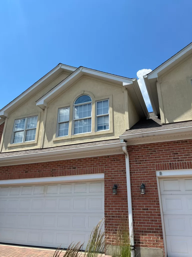 Residential property exterior renovation showcasing upgraded garage doors and roofing