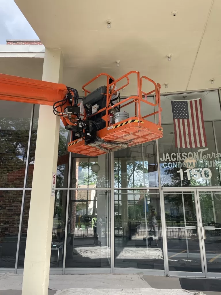 Construction team using lift equipment for high-access exterior maintenance project
