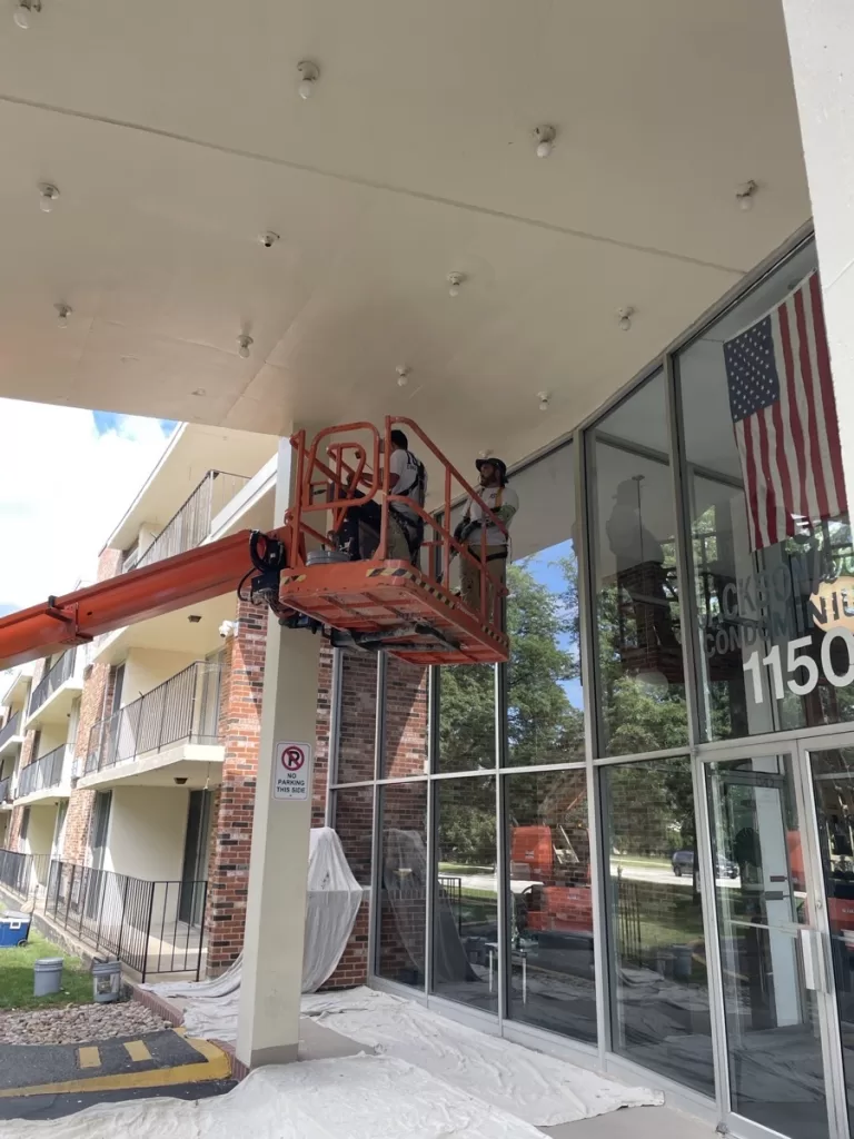 Construction team using lift equipment for high-access exterior maintenance project