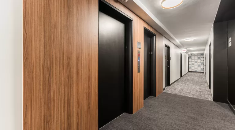 Renovated elevator lobby with wood-accented walls and durable flooring