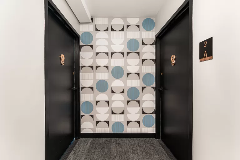 Multifamily hallway remodel featuring wood accents and updated flooring.
