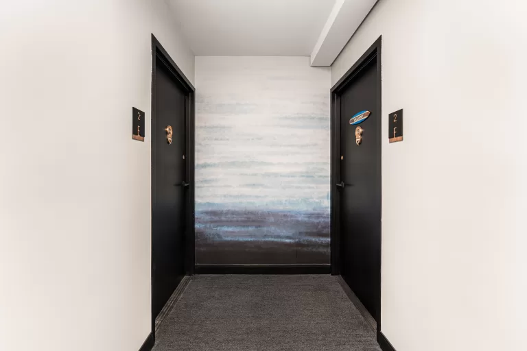 Multifamily hallway remodel featuring wood accents and updated flooring.