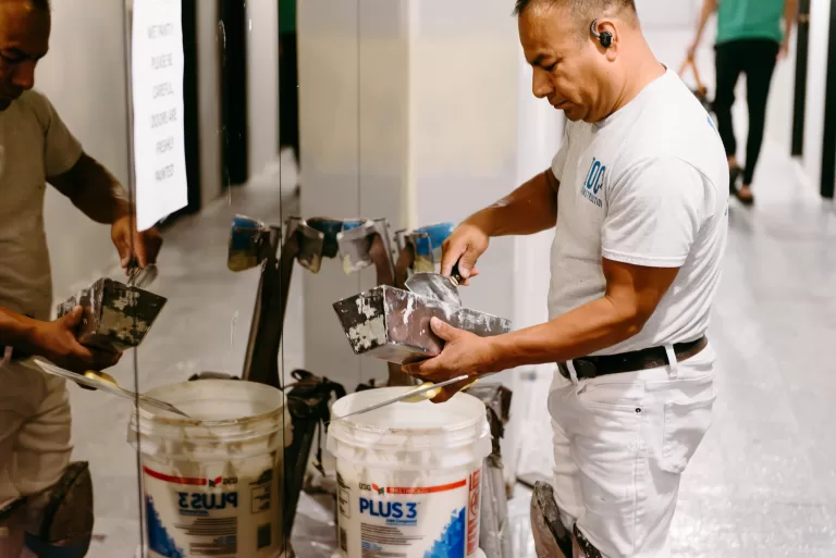 Construction worker mixing materials for commercial renovation project