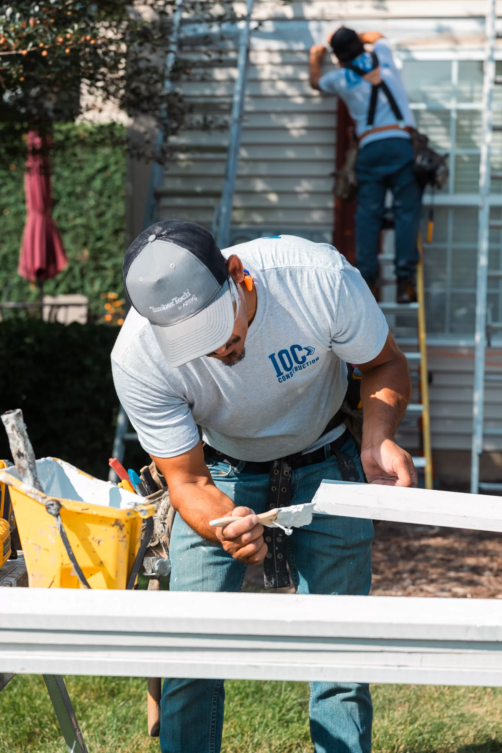 Skilled technicians performing maintenance and exterior upgrades on building facade at IOC Construction